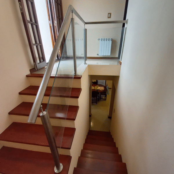 Baranda de vidrio templado con parantes de acero inoxidable instalada en escalera moderno